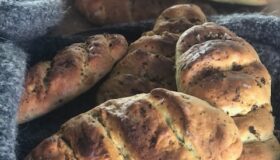 Fertige Bärlauch-Fougasse knusprig und rustikal präsentiert auf einer grauen Decke noch heiß aus dem Ofen zum auskühlen.