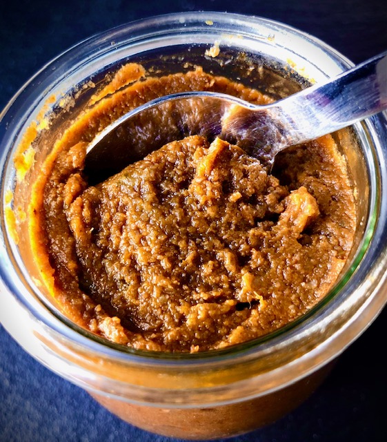 Basis einer pastösen Bratensauce in einem Glas zur Aufbewahrung mit einem Löffel.