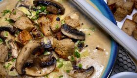 Brotsuppe mit Champignons in einer dekorativen Schüssel zum Servieren.