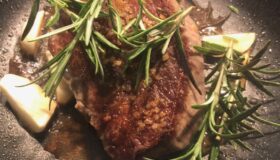 Filetsteak in der Pfanne mit Rosmarinzweigen und 2 Knoblauchzehen
