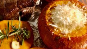 Leckeres Steak und gefüllter Kürbis mit cremigem Trüffel-Kartoffelbrei auf Folie präsentiert.