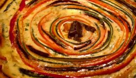 Eine Gemüse Quiche mit vielen Farben in der Form duftend warm und frisch aus dem Ofen