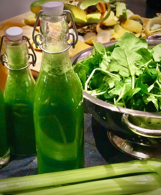 Ein grüner frischer Entgiftungssaft mit Spinat in Flaschen abgefüllt.