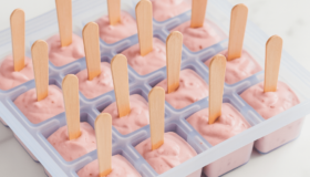 Rosa Himbeereis an einem Holzstiel in Silikon Eiswürfelform zum praktischen herausnehmen. Eisgekühlt lecker aus dem Gefrierfach.