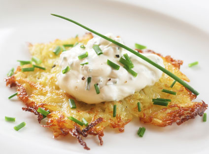 Rösti Hüttenzauber, mit frischem Schnittlauch auf einem weißen Teller serviert.