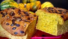 Kürbisbrot in der Coox-Wunderform gebacken und im Hintergrund mit Kürbissen dekoriert.