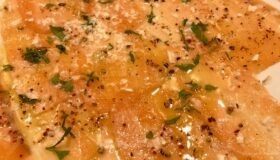 Leckere Scheiben eines Lachs Carpaccio auf einem Teller.