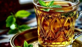 Frisch aufgeossener marokkanischer Minztee mit frischer Minze in einem Glas wie in Marokko.