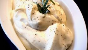 Selbstgemachte Mayonnaise mit einem frischen Rosmarin-Zweig in einer dekorativen Schale serviert.