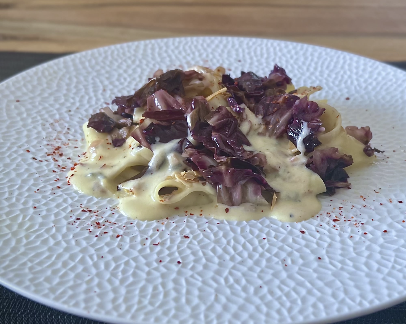 Pappardelle mit Radicchio auf einem weißen Teller serviert.