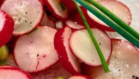 Radieschen-Salat mit frischem Schnittlauch auf einem dekorativen Teller serviert.