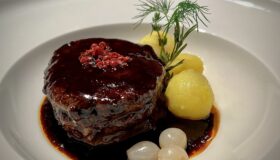 Rinderfielt mit Balsamico Sosse auf einem weißen Teller serviert.