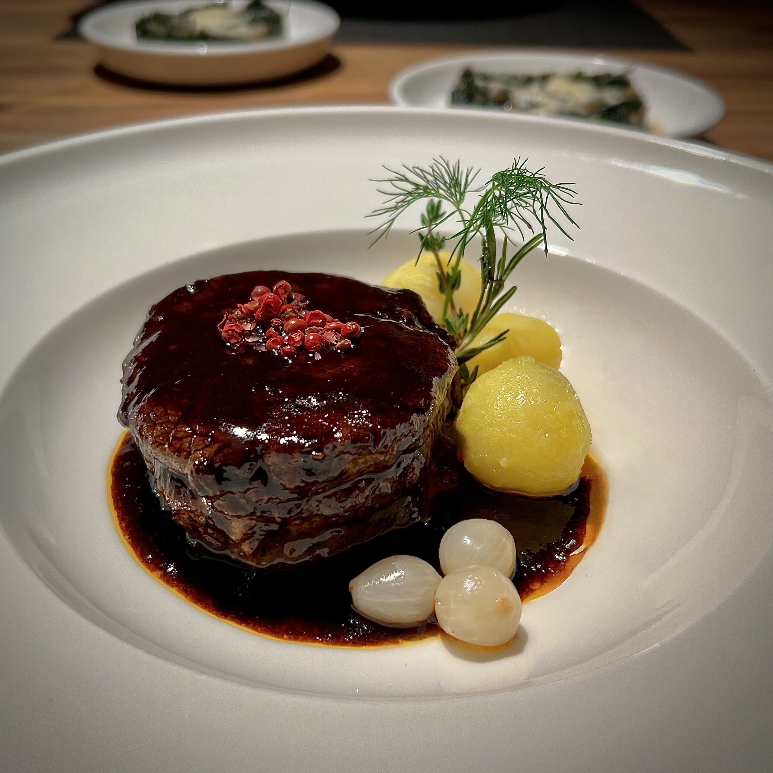 Rinderfielt mit Balsamico Sosse auf einem weißen Teller serviert.