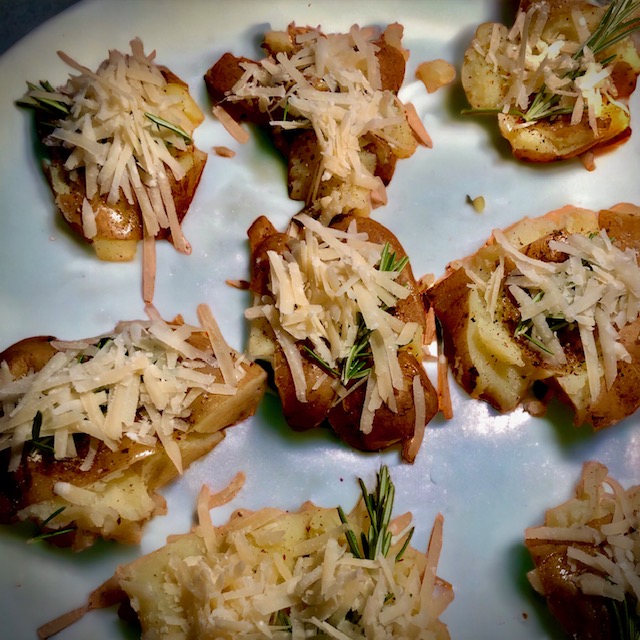 Smashed Potatoes mit Rosmarin und Parmesan belegt.