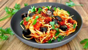 Spaghetti alla Puttanesca in einer grauen Schale serviert.