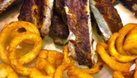 Spareribs mit einer Honig-Senf-Marinade im Ofen sanft gegart und frittierten Kartoffel-Spiralen serviert.