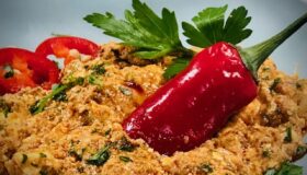 Türkische Schwiegermuttercreme mit einer Chillischote in einer Schale angerichtet.