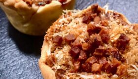 Weißkohl-Muffins auf einer grauen Schieferplatte serviert.
