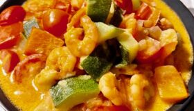 Wok-Gemüse mit Garnelen im einer Schale serviert.