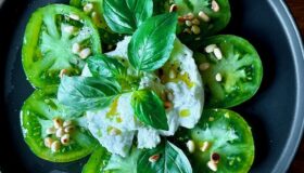 Zebra Caprese (Tomatensalat Caprese) mit gerösteten Pinienkernen und frischem Basilikum garniert.